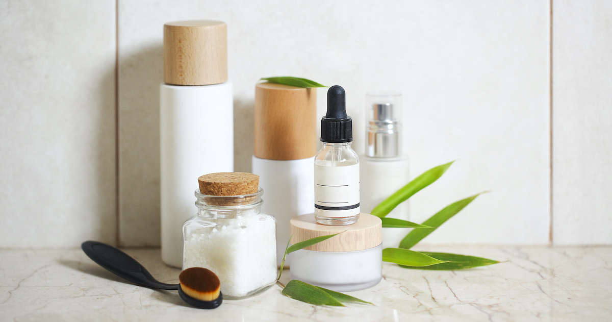 Face cream, serum, lotion, moisturizer and sea salt among bamboo leaves