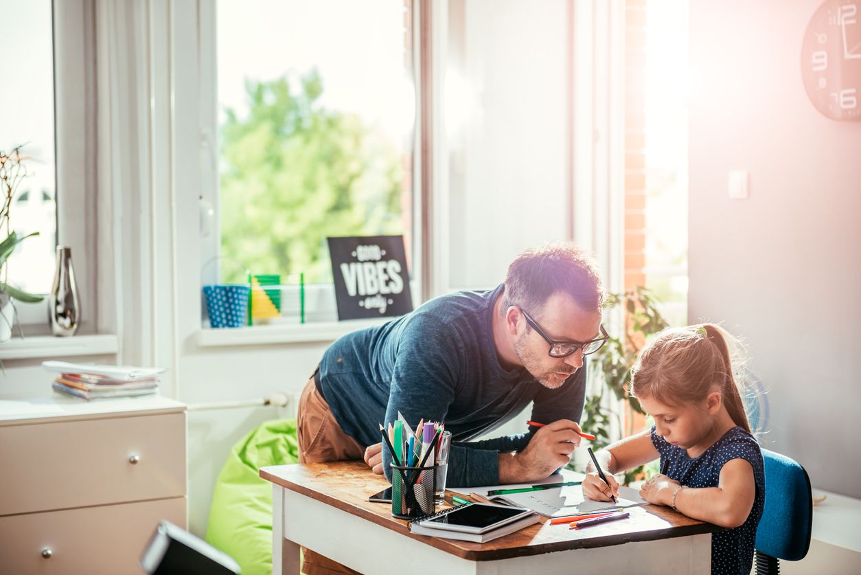 Father helping daughter to finish homework