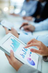 Image of human hand pointing at touchscreen in working environment at meeting