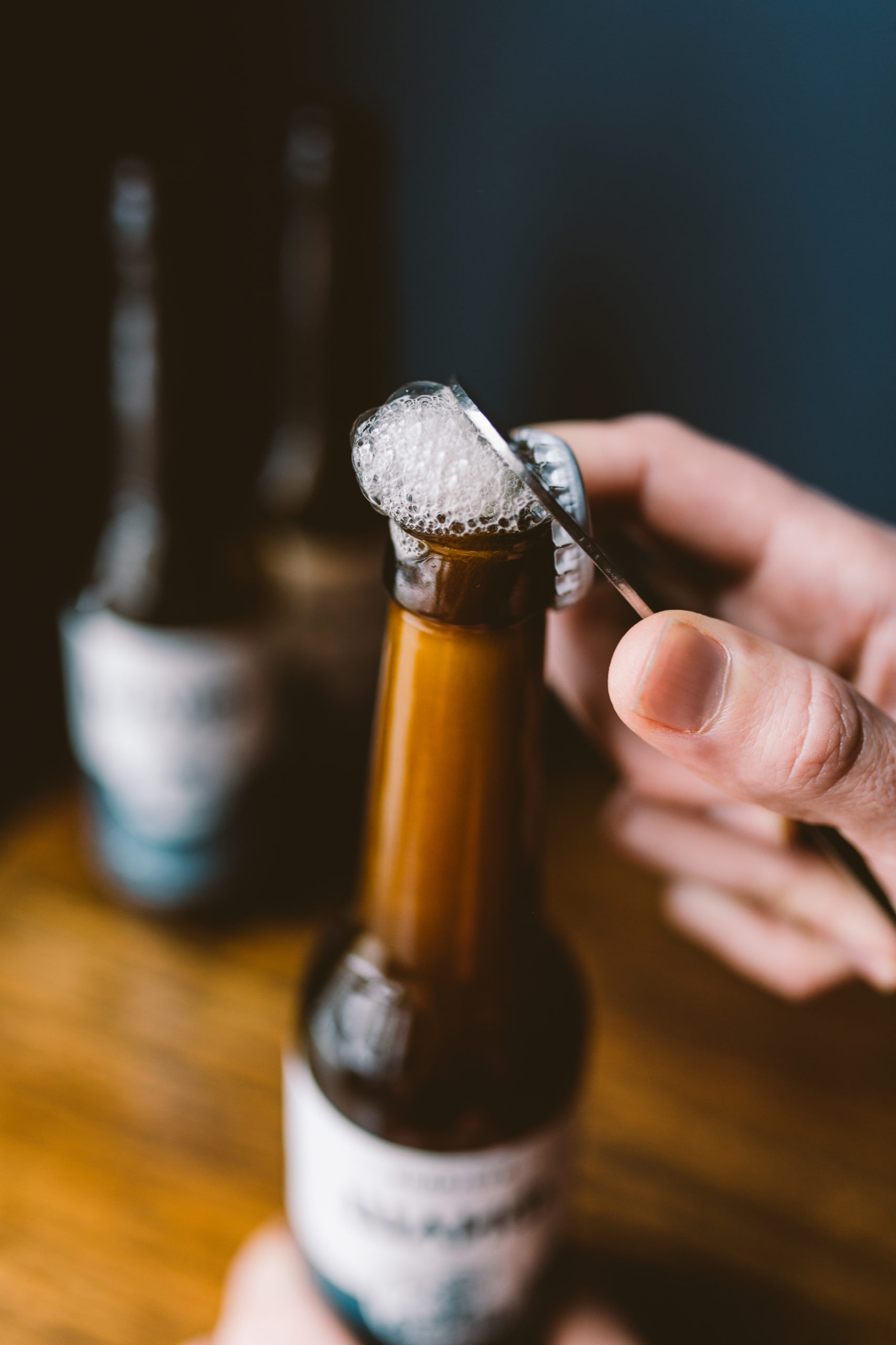 Hand opening a bottle of beer