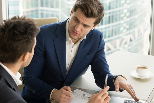 two men talking over paperworks