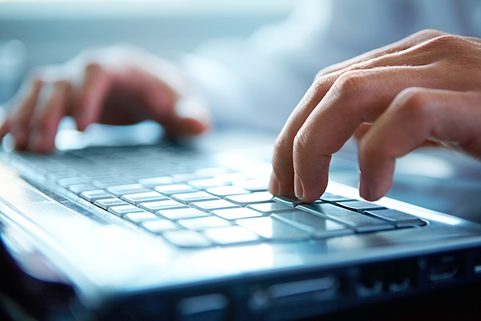 man typing on computer