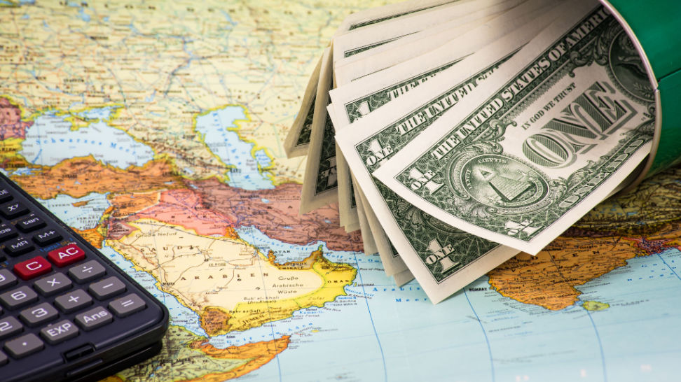 calculator and dollar bills on map background