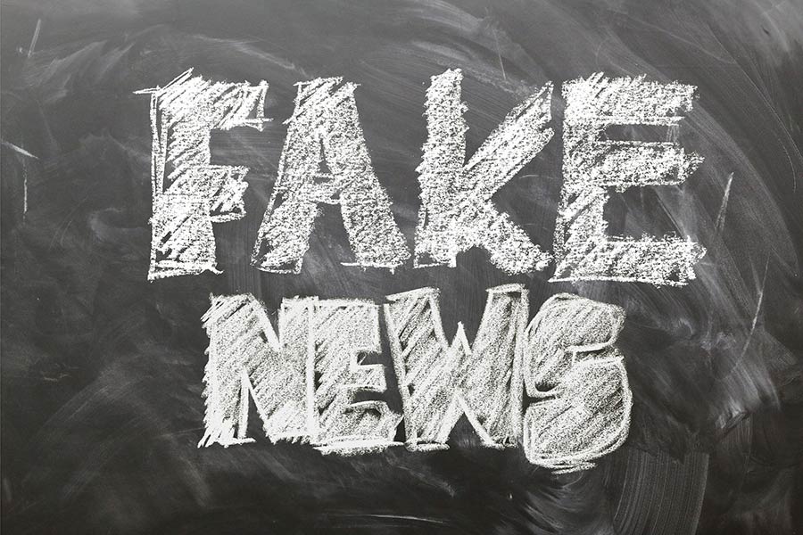 Fake news written on a chalk board
