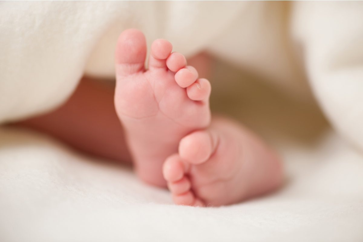 a close up of a baby's feet laying on a blanket.