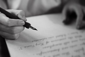 Retro effect faded and toned image of a girl writing a note with a fountain pen antique handwritten letter page document poet journalist lawyer business plan study ccontract letter pen memory report