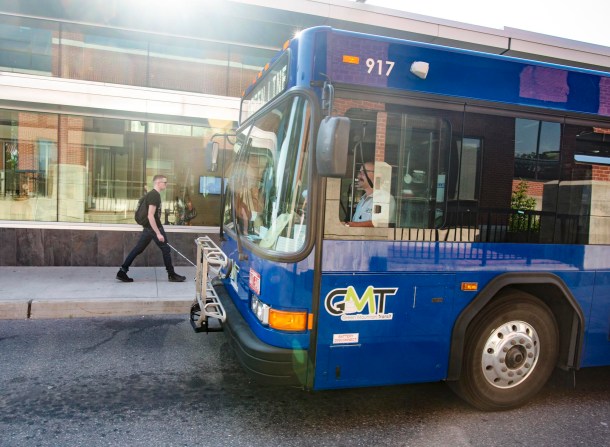 The front of a blue GMT bus at a stop