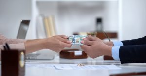 Male and female hands pulling money, dividing marital property during divorce
