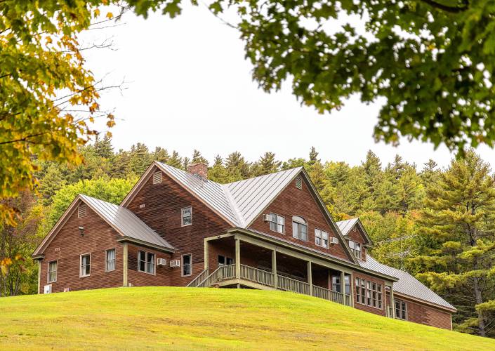 A large brown house sits on top of a hill.