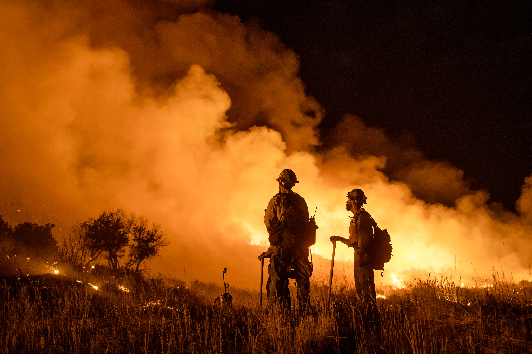Firefighters look on as flames engulf Pine Gulch, Colorado, in 2020. 