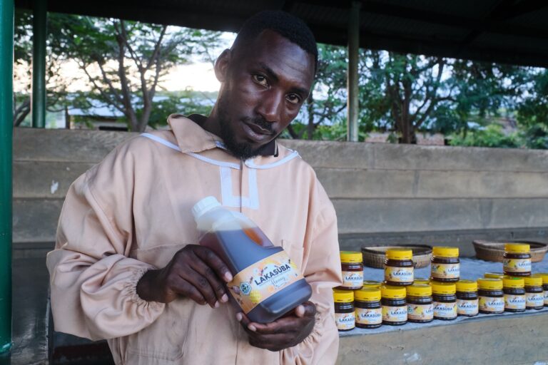 Chris Mongly showing off honey from his beehives. Image by Ashoka Mukpo for Mongabay.