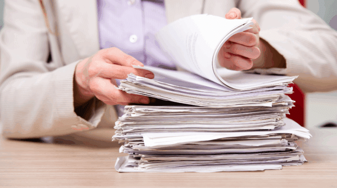Hands of a person thumbing through a paper case file