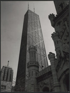 Photograph shows John Hancock Center designed by Bruce Graham for Skidmore, Owings & Merrill framed by old Water Tower, Chicago, Illinois.