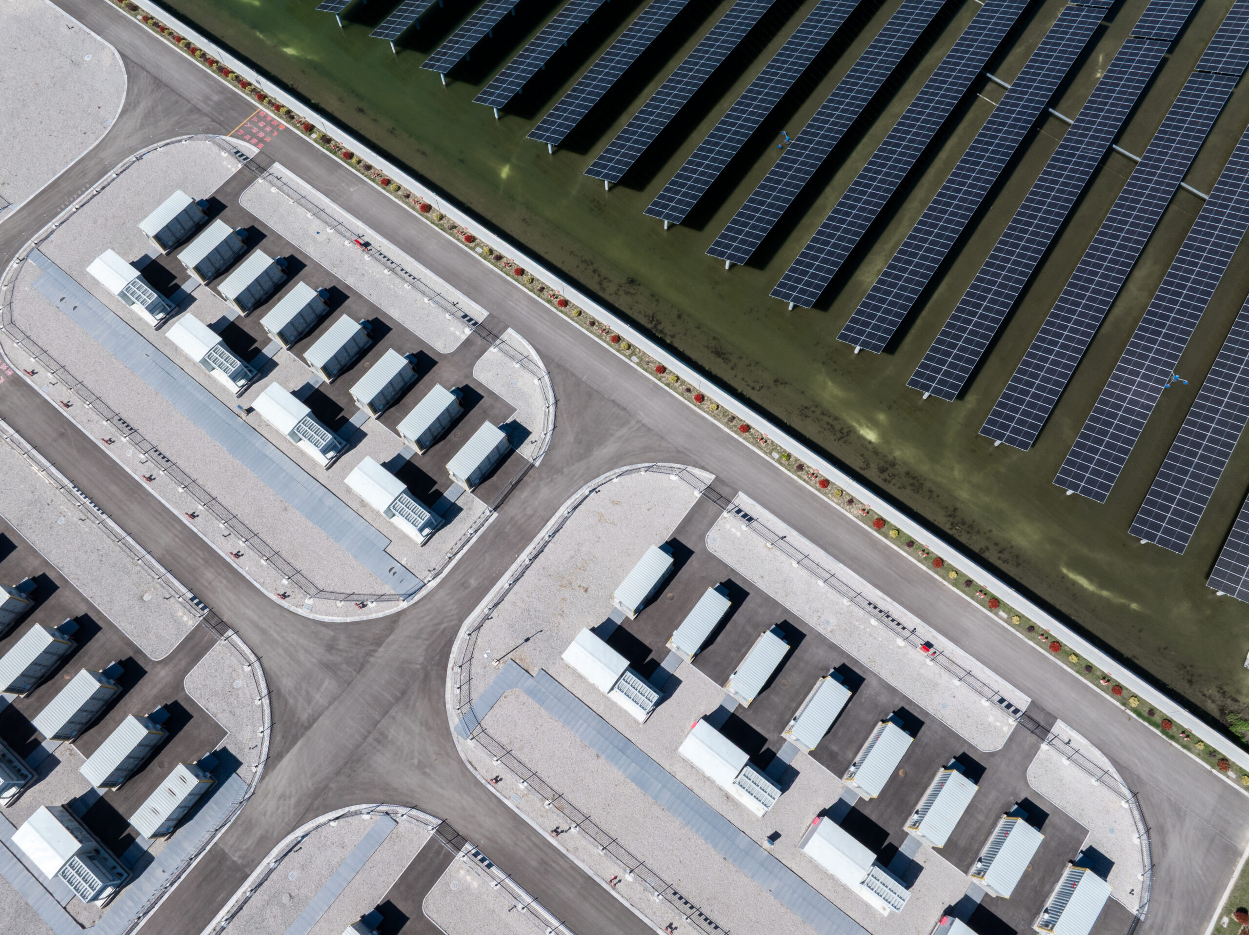 Aerial view of a solar power plant with energy storage facilities and photovoltaic panel arrays