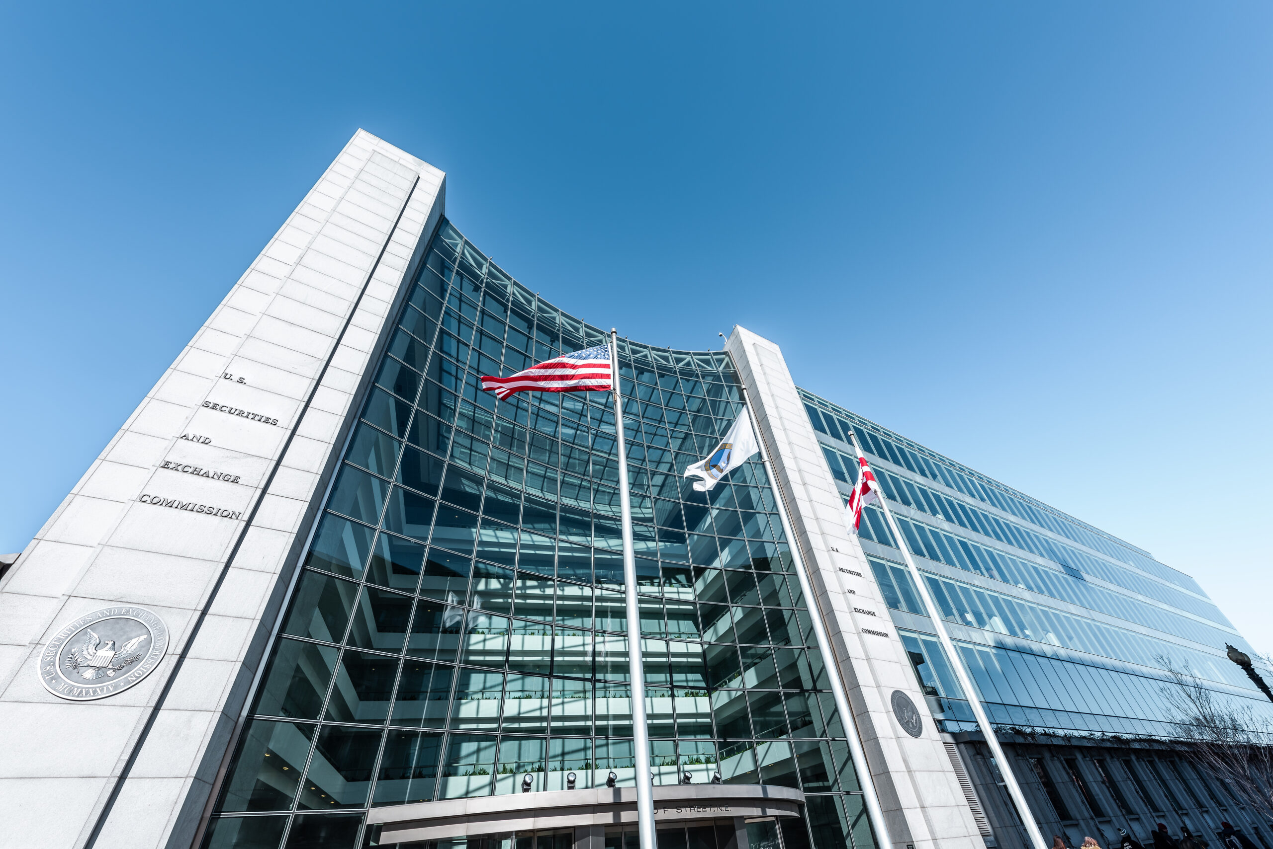 US United States Securities and Exchange Commission SEC entrance architecture modern building sign, entrance, american flag, looking up sky, glass windows reflection